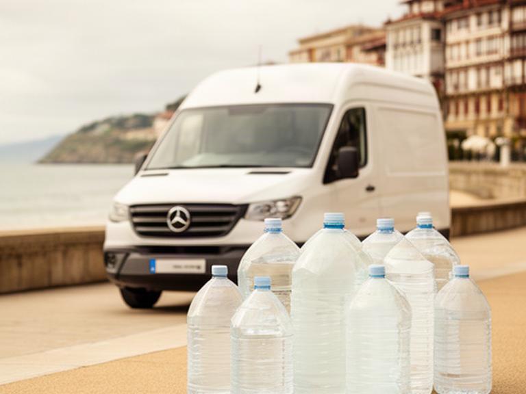 Botellones de agua fresca junto a una furgoneta de reparto en un paseo de San Sebastián